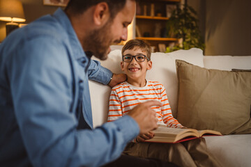 Father and son read a book and have fun while spend time together