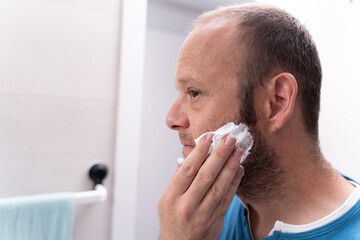 Obraz premium Morning Routine: Young Man Applying Shaving Foam