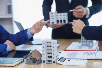 group of businessmen and investors discuss investing in real estate and jointly plan investments in...
