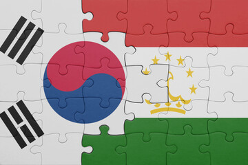 puzzle with the colourful national flag of tajikistan and flag of south korea.