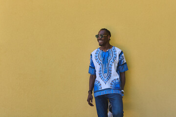 Sudanese Tradition Meets Modern Youth: African American Teen in Vibrant Traditional Attire Against a Yellow Backdrop