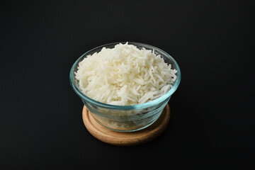 a small serving of basmati rice in a glass bowl on a black background