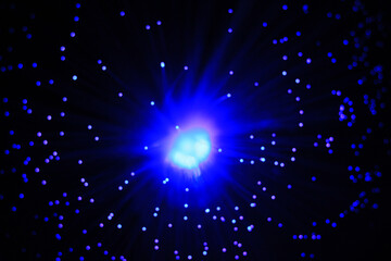 Abstract navy blue flash on a black background and glowing particles