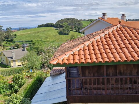 Horreao (grain barn) in Asturias, Spain, with rolling green hills and sea in the background - rural area, remote village