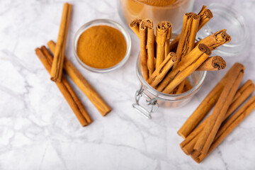 Ceylon cinnamon.Cinnamon sticks on a textured wooden background. Cinnamon roll and powder. Spicy spice for baking, desserts and drinks. Fragrant ground cinnamon. Close-up. Place for text. copy space