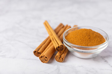 Ceylon cinnamon.Cinnamon sticks on a textured wooden background. Cinnamon roll and powder. Spicy spice for baking, desserts and drinks. Fragrant ground cinnamon. Close-up. Place for text. copy space