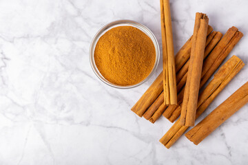 Ceylon cinnamon.Cinnamon sticks on a textured wooden background. Cinnamon roll and powder. Spicy spice for baking, desserts and drinks. Fragrant ground cinnamon. Close-up. Place for text. copy space