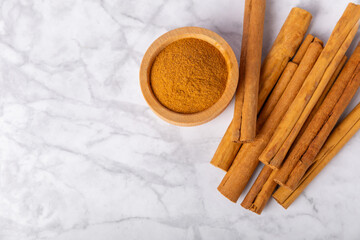 Ceylon cinnamon.Cinnamon sticks on a textured wooden background. Cinnamon roll and powder. Spicy spice for baking, desserts and drinks. Fragrant ground cinnamon. Close-up. Place for text. copy space