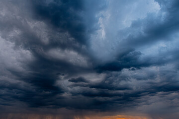 A captivating view of dark, swirling storm clouds filling the sky, creating a dramatic and moody atmosphere. The interplay of light and shadow highlights the intensity of the impending weather.