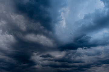 A captivating view of dark, swirling storm clouds filling the sky, creating a dramatic and moody atmosphere. The interplay of light and shadow highlights the intensity of the impending weather.