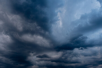 A captivating view of dark, swirling storm clouds filling the sky, creating a dramatic and moody atmosphere. The interplay of light and shadow highlights the intensity of the impending weather.