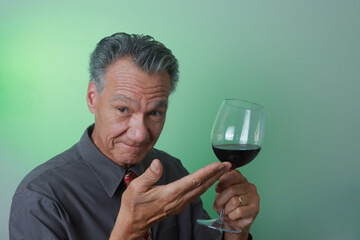 Mature Man smiling and holding up a big glass of red wine