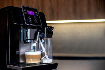 Modern coffee machine with glass cup of latte in kitchen