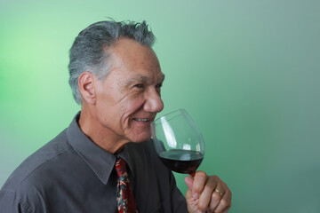 Mature Man smiling and enjoying a big glass of red wine

