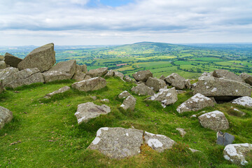 Pile of large rocks on the summit of Titterstone Clee in Shropshire, UK with Brown Clee Hill on the horizon