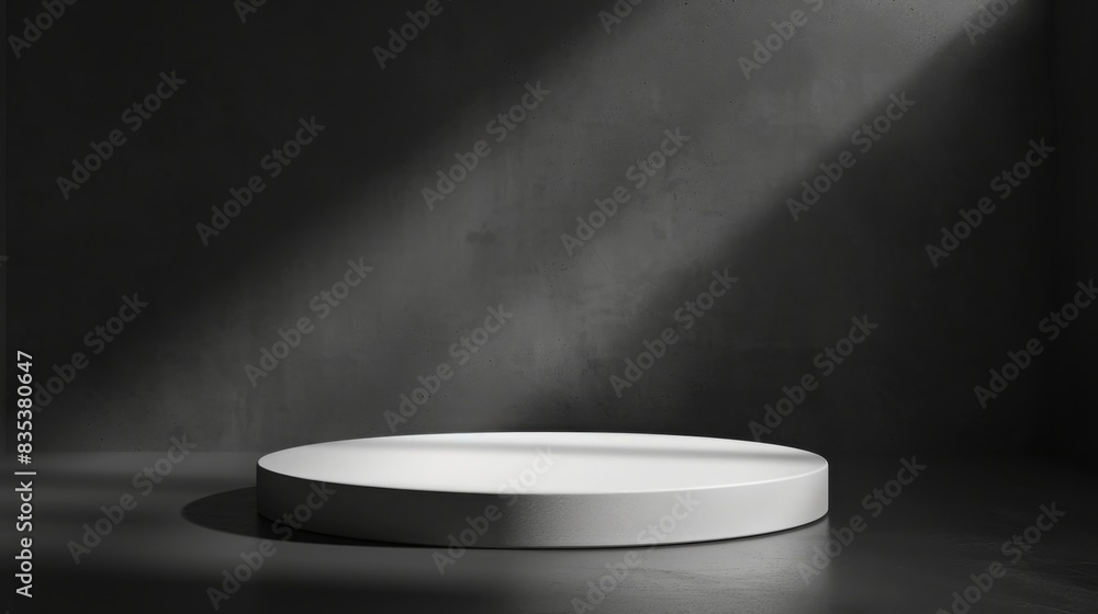 Aufkleber A round white platform is illuminated by a focused light beam in a dark, minimalist studio environment creating a stark contrast.