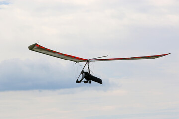 	
Hang Glider flying in a cloudy sky	