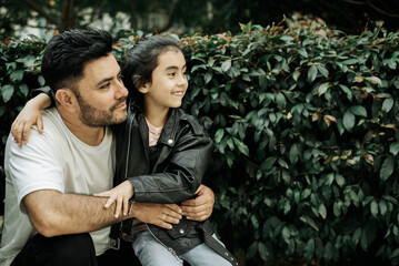 A young father hugging his young daughter