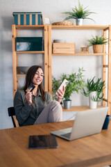 Young woman making convenient financial e-commerce payment digital transaction while sitting at home.