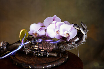 Mano di robot e l'orchidea rosa sopra una tavola di legno