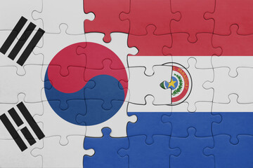 puzzle with the colourful national flag of paraguay and flag of south korea.