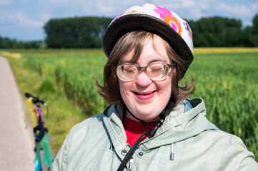 Outdoor portrait of a 41 yo woman with the Down Syndrome, eyes closed, Tienen, Belgium