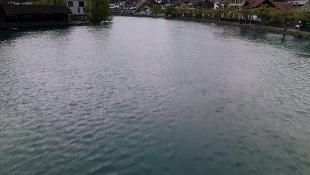 Aar river Interlaken Switzerland town snowy alps drone aerial reveal cloudy day