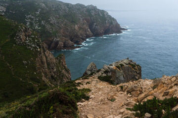 Coastline of Portugal, Cabo da Roca. Cape Roca in Sintra. The lighthouse in Cabo da Roca. Cliffs and rocks on the Atlantic ocean coast. Cloud day
