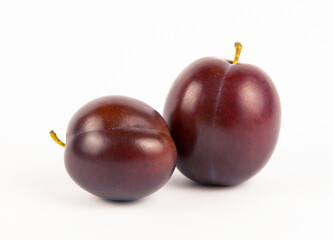 Close-up of two purple plums, front view.