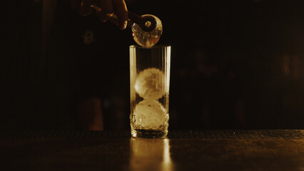 Glass with balls of ice on the bar counter
