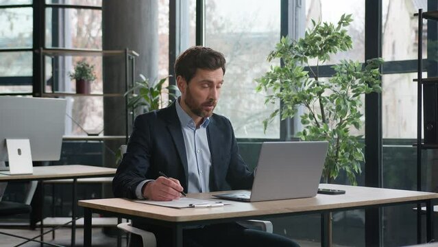 Caucasian man businessman manager consultant male leader entrepreneur boss sales representative talking video call online conference business chat remote meeting using laptop in office writing notes