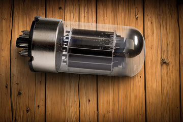 Vintage Electrical Vacuum Tube with Metallic Pins on Wooden Surface