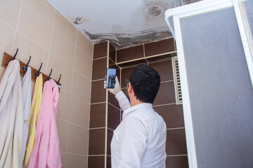 Expert takes photo of moldy bathroom ceiling