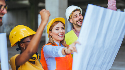 Cheerful diverse team of construction professionals, clad in hard hats and safety vests, engage...