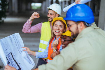 A spirited group of diverse construction professionals in safety helmets and vests enthusiastically...