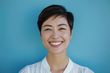 Fototapeta premium An unidentified person in a white shirt stands against a blue background with a neutral expression