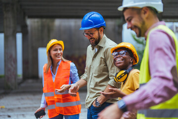 A multicultural crew of construction workers, including a cheerful woman in a reflective vest,...