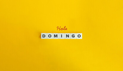 Hola Domingo (Hello Sunday) in Spanish Language. Text on Block Letter Tiles on Yellow Background....