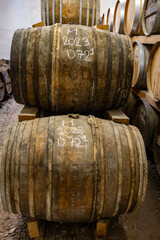 Aging process of cognac spirit in old dark French oak barrels in cellar in distillery house, Cognac...