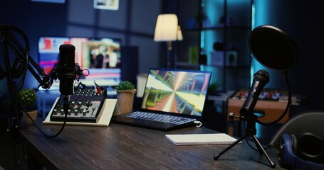 Jib down shot of wooden desk in studio with podcast gear technology recording sound for social...