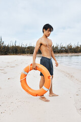 Lifeguard on the Beach, a Summer Savior - Asian Man with Lifebuoy, Ensuring Swim Safety and Rescue...
