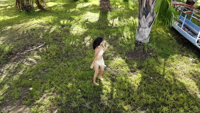 Mujer ind&iacute;gena Atractiva alegre caminando descalza con disfraz t&iacute;pico en la selva Peruana , celebra el D&iacute;a Internacional de los Pueblos Ind&iacute;genas con canciones tradicionales,vestida en top,bonita,