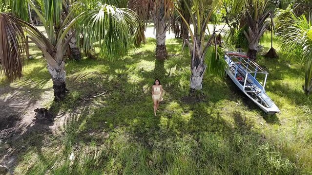 Mujer ind&iacute;gena Atractiva alegre caminando descalza con disfraz t&iacute;pico en la selva Peruana , celebra el D&iacute;a Internacional de los Pueblos Ind&iacute;genas con canciones tradicionales,vestida en top,bonita,