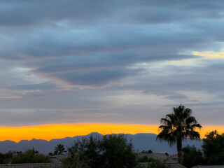 Colorful Desert Sunset, with Palm Tree and Mountains .