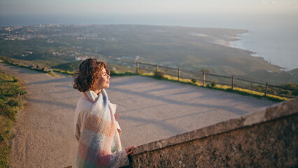 Lady looking scenic coastline at sunset standing stone stairs. Woman traveler 