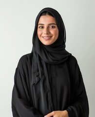An elegant saudi gulf woman wearing a hijab stands with arms crossed isolated on the background