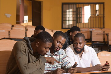 Happy young African university students studying with books in school library