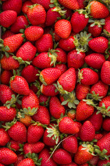 A wooden crate brimming with fresh, ripe strawberries, bursting with vibrant red color and juicy sweetness, ready to eat