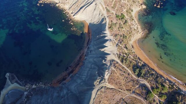Qarraba Bay flat rock cape Malta, Aeriale stablishing shot in the morning sunlight showing hiking trekking path and two beaches on both side. High quality 4k footage