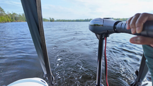 Close up of trolling electric motor at inflatable boat while boating at the lake. Leisure activity of travelling by boat and recreational use of boat vessel. Sports activities fishing and exploring.